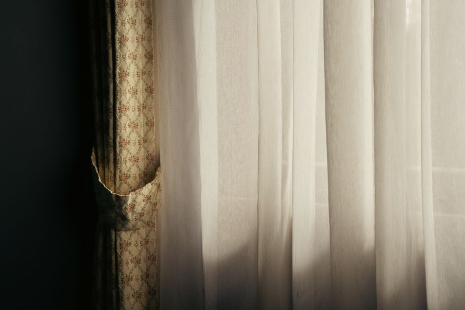 Warm sunlight filtering through elegant curtains in a Tokyo room, creating a serene ambiance.